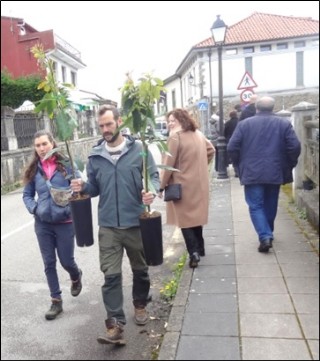 Una pareja camino de su vehculo con plantones, tras visitar el Festival.