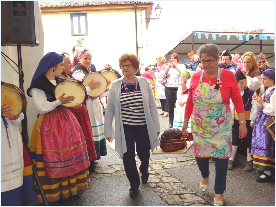 Ah viene. La protagonista de la fiesta es introducida en el interior de la carpa por Lucita Campos y Clarita Joven, para ser llevada al escenario, a los acordes de las pandereteras de Bimenes./ Foto: EL ECO.	