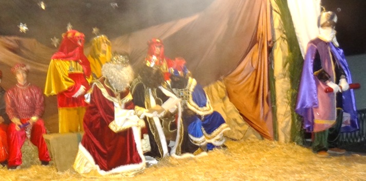 Los tres Reyes Magos, enfrascados en la lectura, por ambas caras, de una carta. A la derecha, su Príncipe Aliatar, con el pergamino del mensaje que leyó.