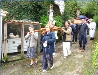 La procesin descendiendo de la Capilla, a su paso por delante de un gallinero. En la pgina anterior, la imagen del Santo ngel. | EL ECO