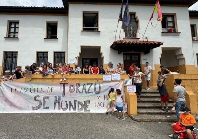La protesta ante el centro educativo de Torazo, el 19 de junio, con una pancarta que rezaba: La Escuela de Torazo se hunde y nadie hace nada. | LNE