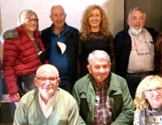 La rubia Mina Longo, entre el secretario (Jos Manuel Menndez) y el presidente de la Agrupacin (Julin Huerta), con otros socios, en Navia.