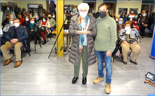 Elsa Huerta mostrando el Premio que recogi en nombre de Mases, con parte del pblico detrs.