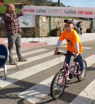 Izan Garc�a entrando en meta, con el concejal Iv�n Riego a la izquierda.