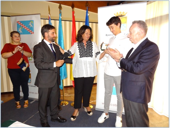 Irene Garca apoya sus manos en el Alcalde y en su hijo, Rafael, que observa la distincin recibida. Manuel Rodrguez y la concejala de Torazo, Virginia Naredo, aplauden. / EL ECO