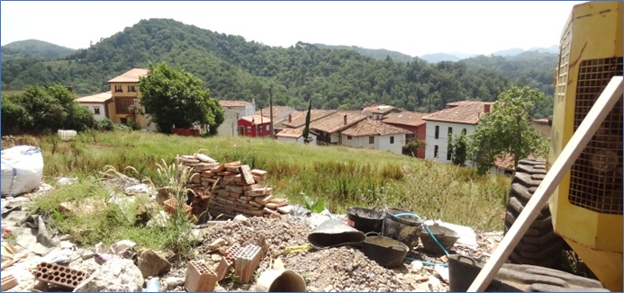 Parcela sobre la que se levantar la urbanizacin. En primer plano, materiales y maquinaria de la obra que se realiza en vivienda inmediata, de la misma propiedad.