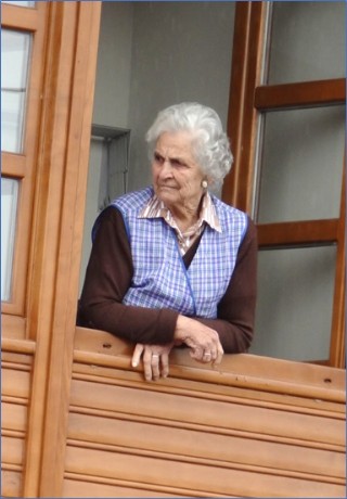 Asomada a una ventana de la casa de su hijo en El Llanu, pendiente del Rallye Prncipe de Asturias, el 16 de septiembre de 2017. | Fotos: EL ECO, Archivo