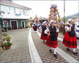 Los ramos pasando ante la casa de Nieves, con la bandera de Asturias encogida
