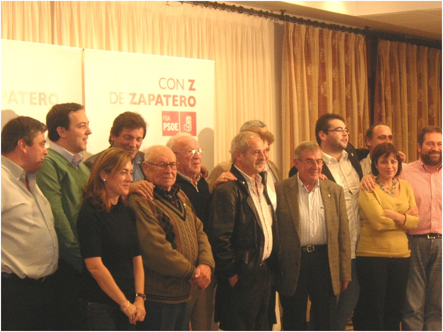Javier Fernndez apoya sus manos abrazando los hombros de Urbano. A la izquierda de l, Ana Rosa Migoya, Alejandro Vega y Claudio Escobio (entonces alcalde de Nava y vinculado familiarmente a La Obra). Y a la derecha, una jovencsima Adriana Lastra, hoy n