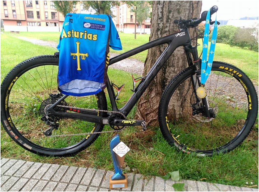 La bicicleta con la que consigui el Campeonato, luciendo los tres trofeos