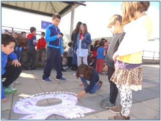 Nios encendiendo las velas sobre el lazo morado