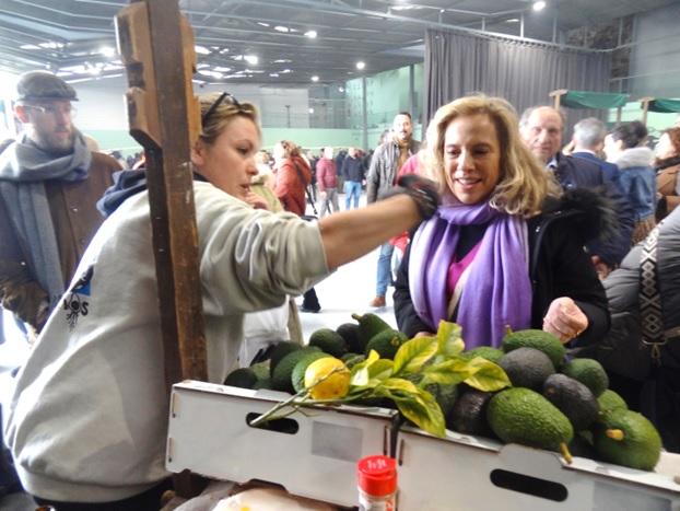 La Consejera de Comercio, Belarmina Daz, comprando en el puesto de la organizacin. A la izquierda, el malagueo Yussuff Lpez.