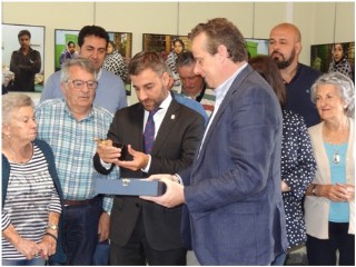 exhibiendo el Alcalde el regalo hecho al Ayuntamiento por Marcelino Lndez (a su izquierda)