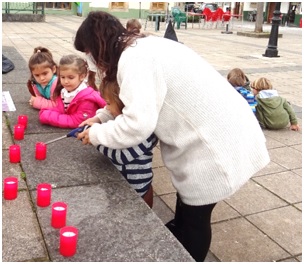 Covadonga Laviada ayudando a los nios a encender las velas./ EL ECO