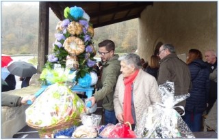Preparando las ofrendas para la subasta, con devotos protegindose de la lluvia fuera del cabildo