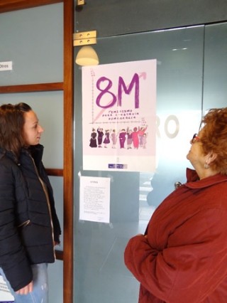 Dos señoras mirando el cartel del 8M