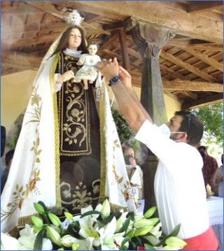 Maximino Díaz poniendo el rosario a la Virgen bendecido por el Papa