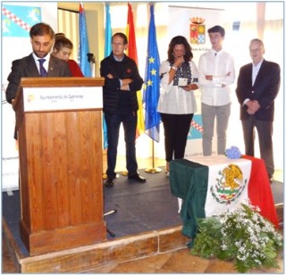 El Alcalde, repasando notas. Irene, con su mirada fija en la Medalla, ante la bandera de México. / EL ECO