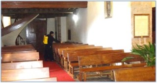 , el hermano Marco Antonio Muñoz (auxiliar de la primera) desinfectando los bancos de la Iglesia